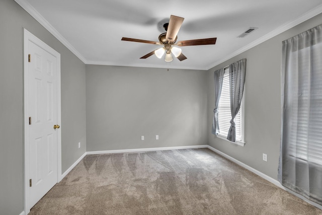 spare room with ceiling fan, light colored carpet, and crown molding