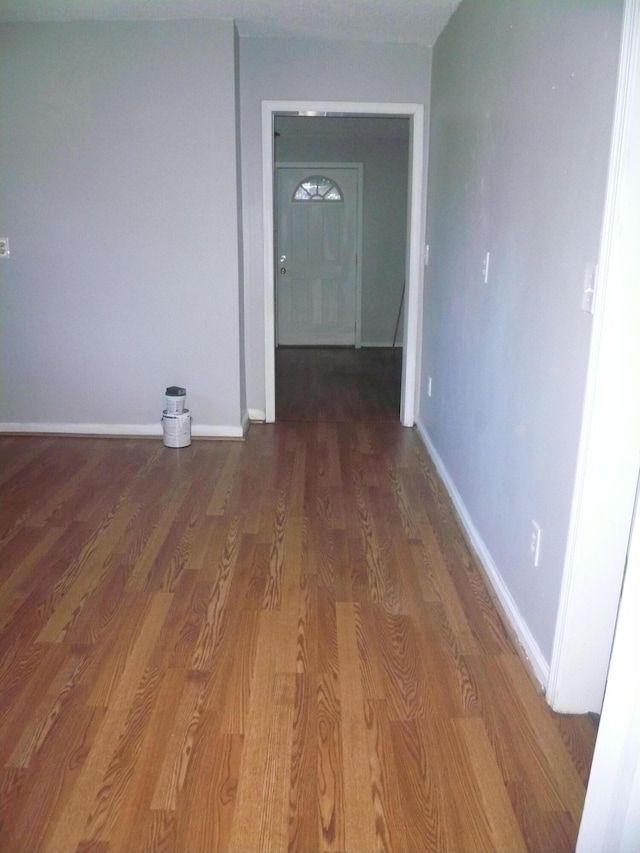 corridor with hardwood / wood-style flooring