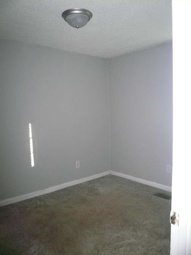 carpeted spare room with a textured ceiling