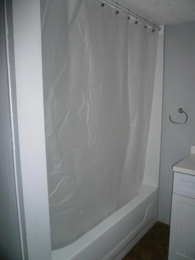 bathroom with vanity, shower / tub combo, and a textured ceiling