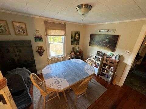 dining space featuring hardwood / wood-style floors and ornamental molding