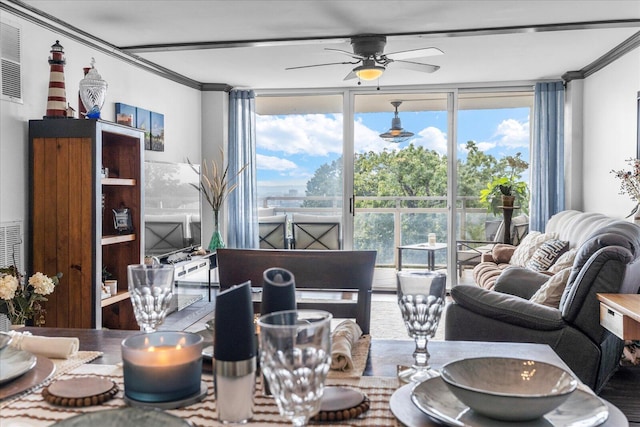 living room with ceiling fan, a wall of windows, and crown molding