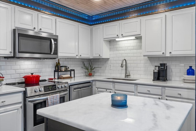 kitchen with white cabinets, appliances with stainless steel finishes, tasteful backsplash, and sink