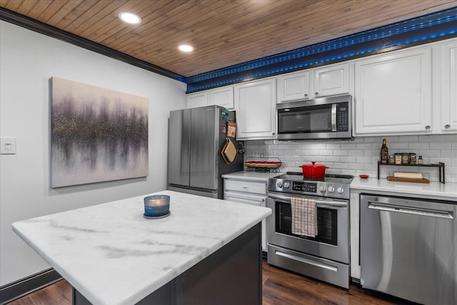 kitchen with white cabinets, a kitchen island, backsplash, and appliances with stainless steel finishes