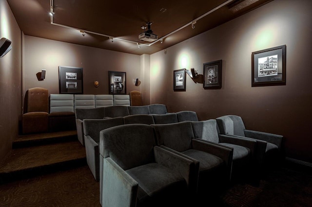 home theater with rail lighting and dark carpet