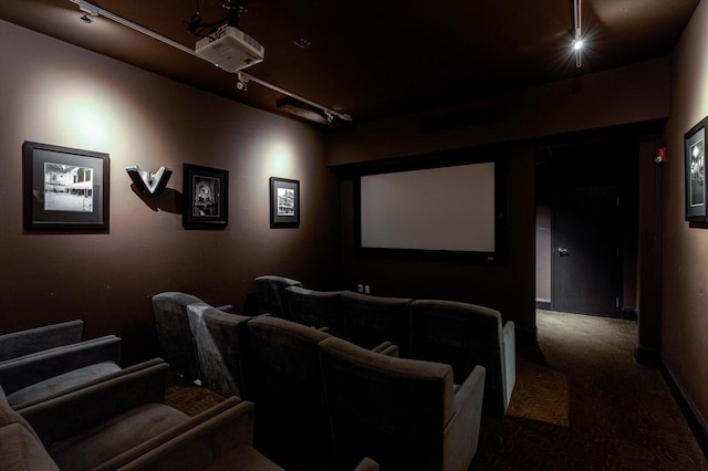 carpeted home theater room featuring rail lighting