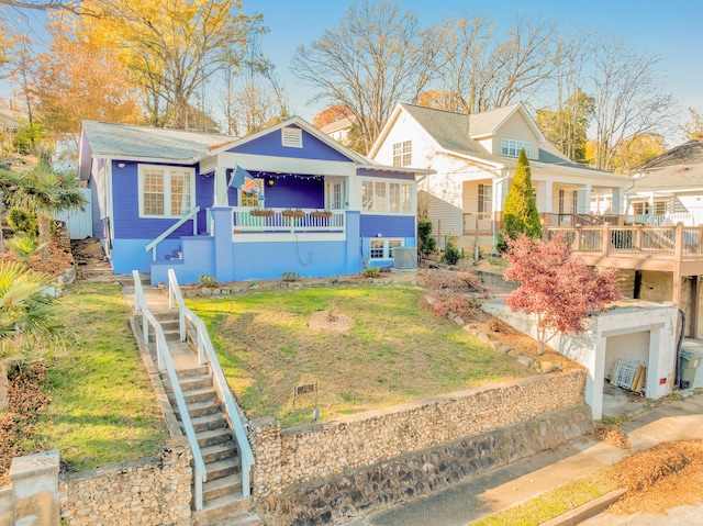 bungalow-style home featuring cooling unit, stairs, and a front yard