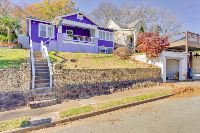 view of front of property featuring a front lawn and stairway