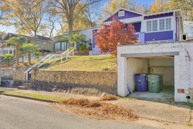 view of front of property with concrete driveway, an attached garage, and a front lawn