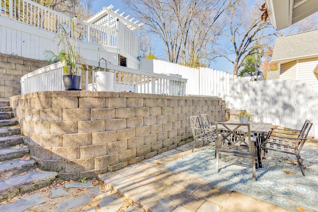 view of patio featuring outdoor dining space and fence