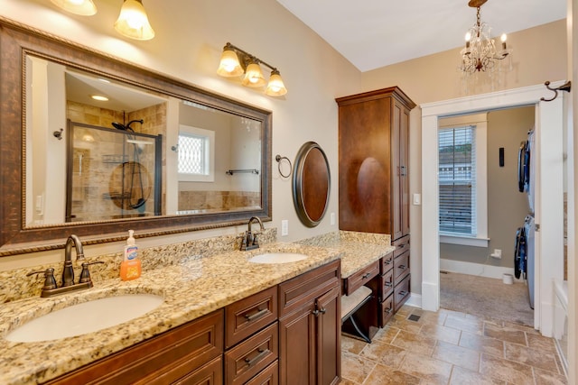 bathroom featuring double vanity, a shower stall, stacked washing maching and dryer, and a sink