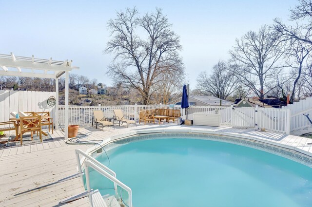 view of pool featuring a gate, a pergola, fence, a wooden deck, and a fenced in pool