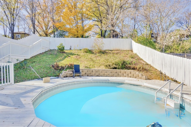 view of swimming pool with a deck, a fenced backyard, and a fenced in pool