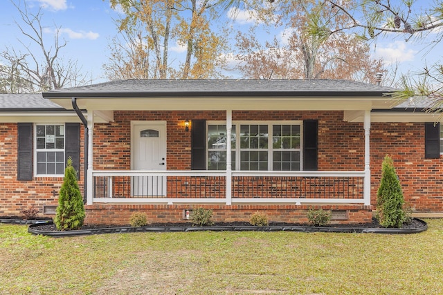 ranch-style home featuring a front lawn and a porch