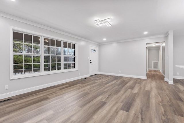 empty room featuring hardwood / wood-style floors and crown molding