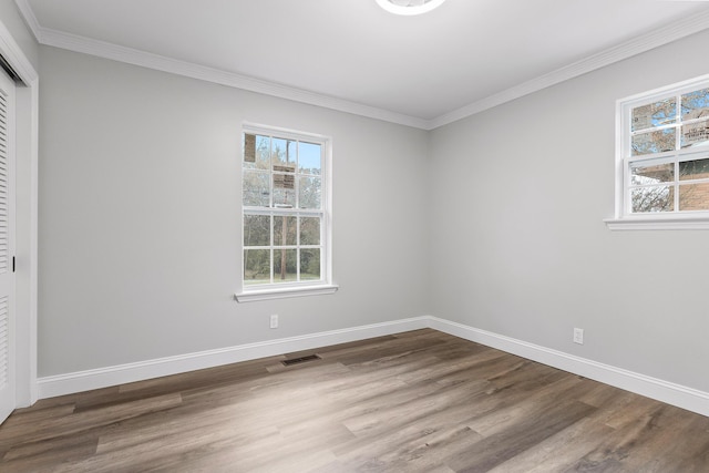 empty room with wood-type flooring and crown molding