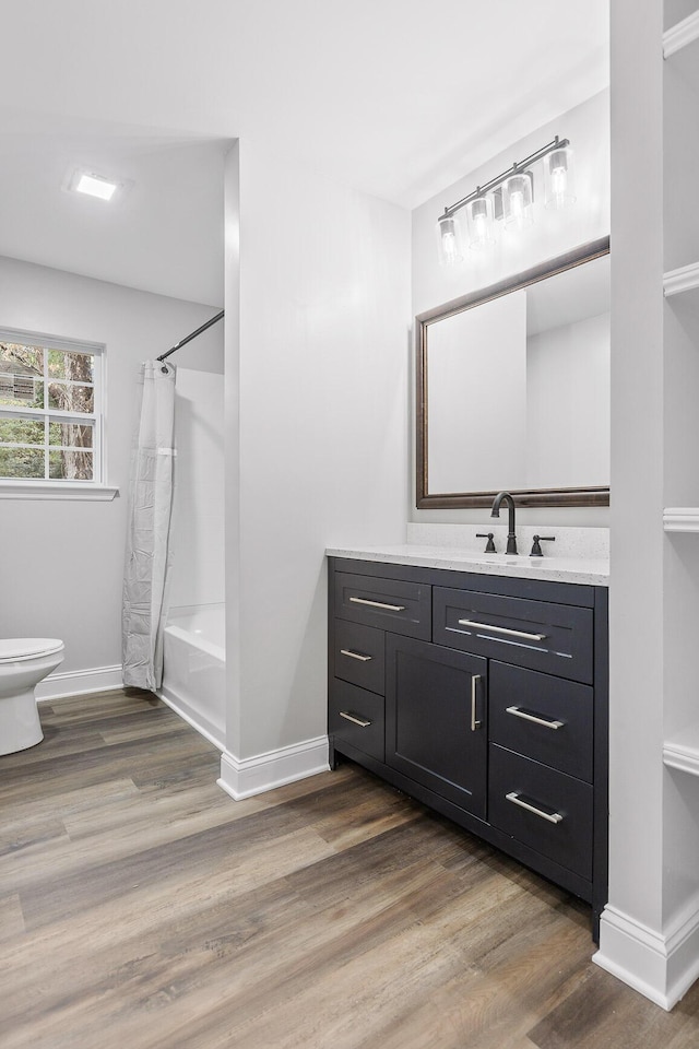 full bathroom featuring wood-type flooring, vanity, toilet, and shower / bathtub combination with curtain