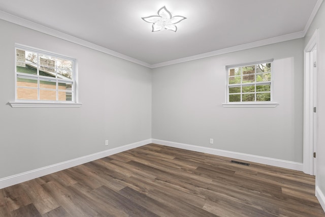 spare room featuring dark hardwood / wood-style flooring, crown molding, and a wealth of natural light