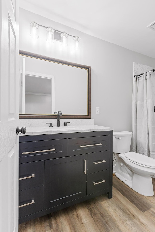 bathroom with toilet, vanity, a shower with shower curtain, and hardwood / wood-style flooring