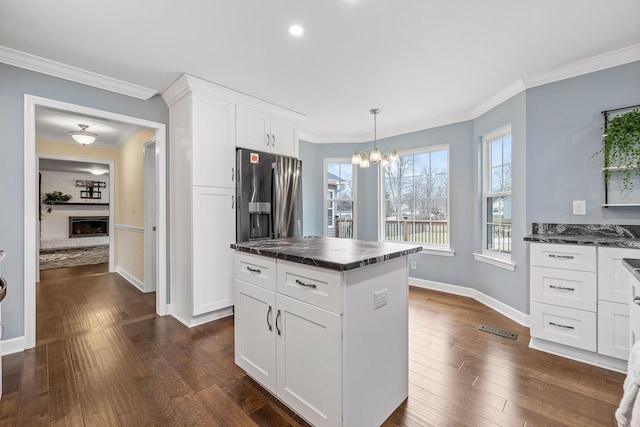 kitchen featuring a center island, hanging light fixtures, stainless steel fridge, dark hardwood / wood-style flooring, and white cabinetry