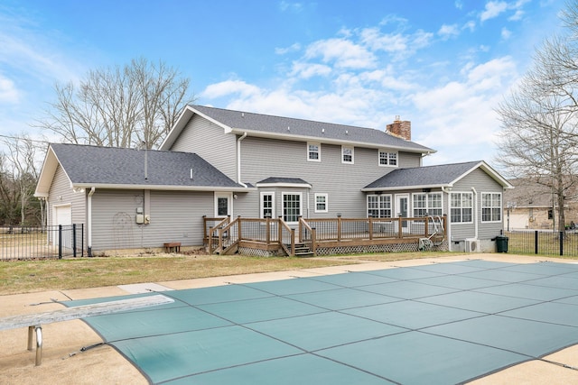 view of pool with a wooden deck, a diving board, and a yard