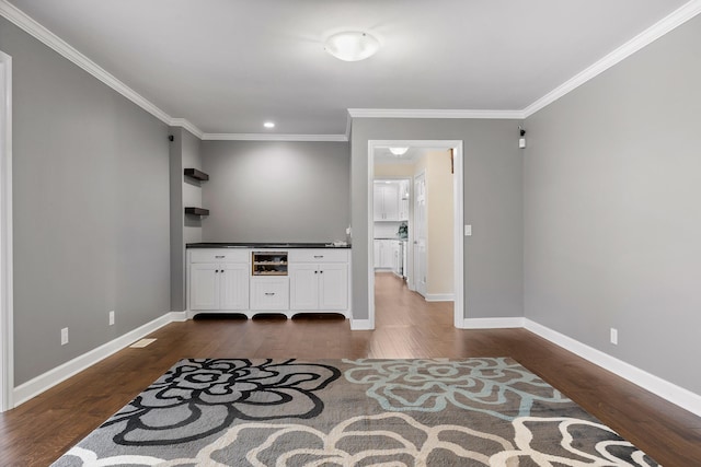 interior space featuring crown molding, dark hardwood / wood-style flooring, and white cabinets