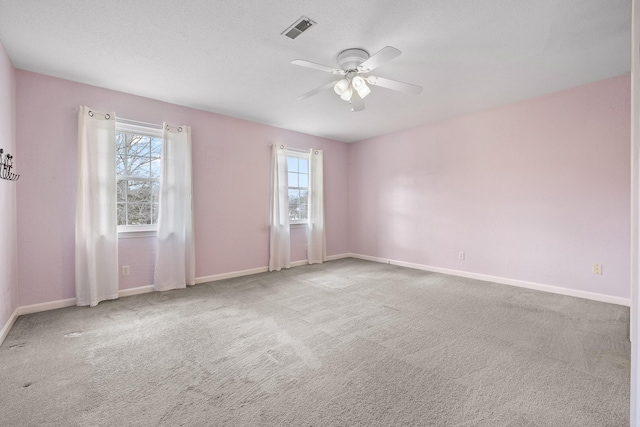 carpeted spare room with a wealth of natural light and ceiling fan