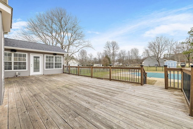 deck with a shed and a covered pool