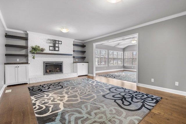 living room with lofted ceiling, dark wood-type flooring, crown molding, ceiling fan, and a fireplace