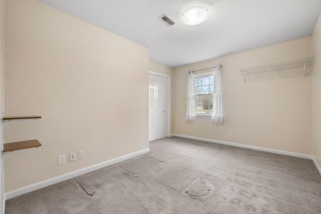 unfurnished bedroom with a textured ceiling, light carpet, and a closet