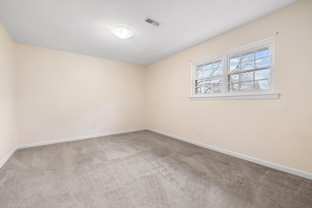 carpeted empty room featuring a textured ceiling