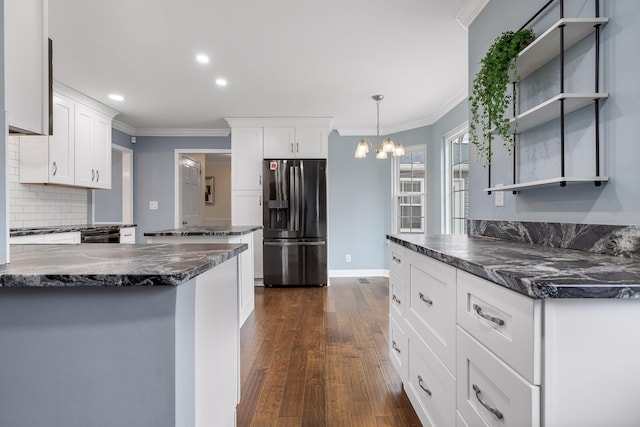 kitchen with dark wood-type flooring, an inviting chandelier, crown molding, stainless steel refrigerator with ice dispenser, and white cabinetry