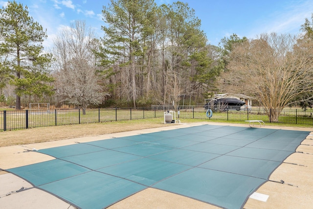 view of swimming pool with a diving board and a yard