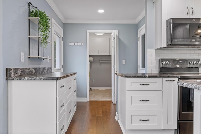 kitchen featuring white cabinets, appliances with stainless steel finishes, and crown molding