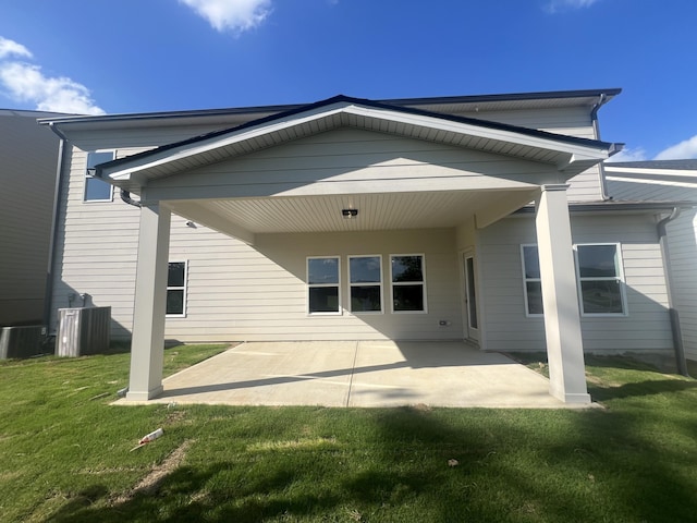 back of property featuring a lawn, central AC, and a patio