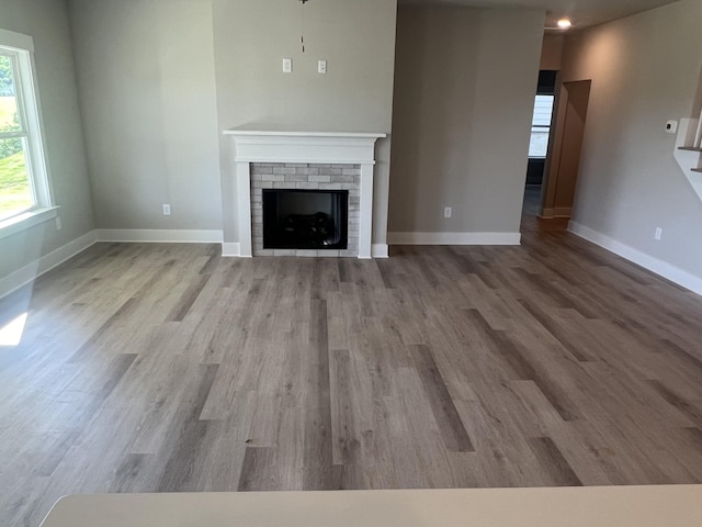 unfurnished living room with light wood-type flooring and a fireplace