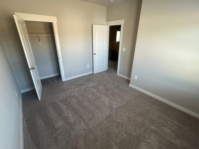 unfurnished bedroom with a closet and dark carpet