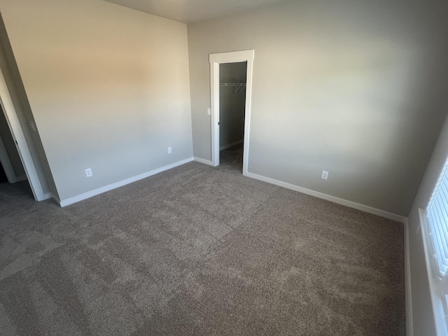 unfurnished room with dark carpet