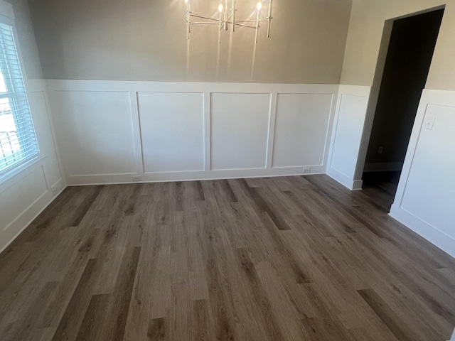 unfurnished dining area with a chandelier and dark hardwood / wood-style floors