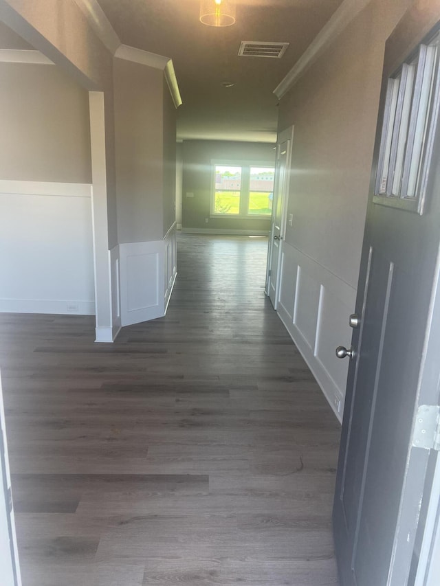 hall with dark hardwood / wood-style flooring and crown molding