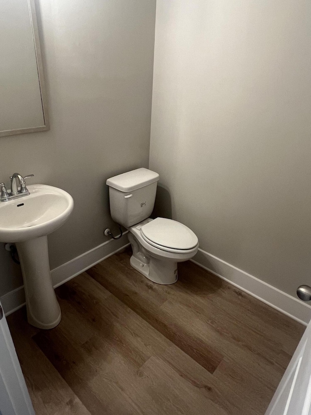 bathroom with hardwood / wood-style floors, toilet, and sink