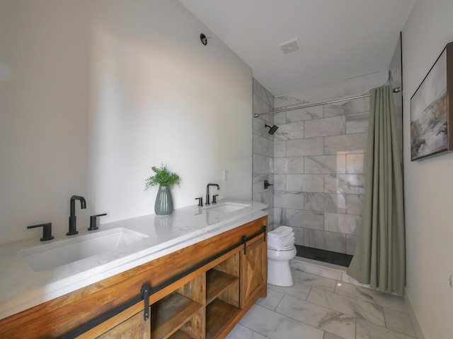 bathroom with a tile shower, vanity, and toilet