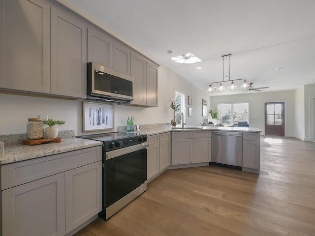 kitchen with gray cabinetry, sink, stainless steel appliances, and light hardwood / wood-style floors