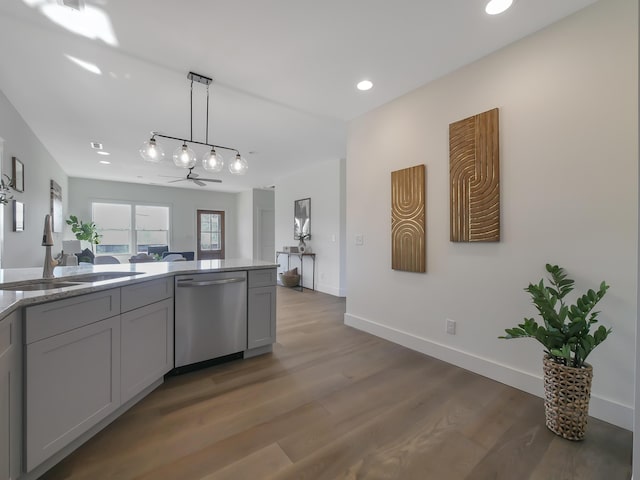 kitchen with stainless steel dishwasher, sink, pendant lighting, gray cabinets, and dark hardwood / wood-style floors