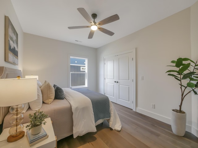 bedroom with a closet, ceiling fan, and dark wood-type flooring