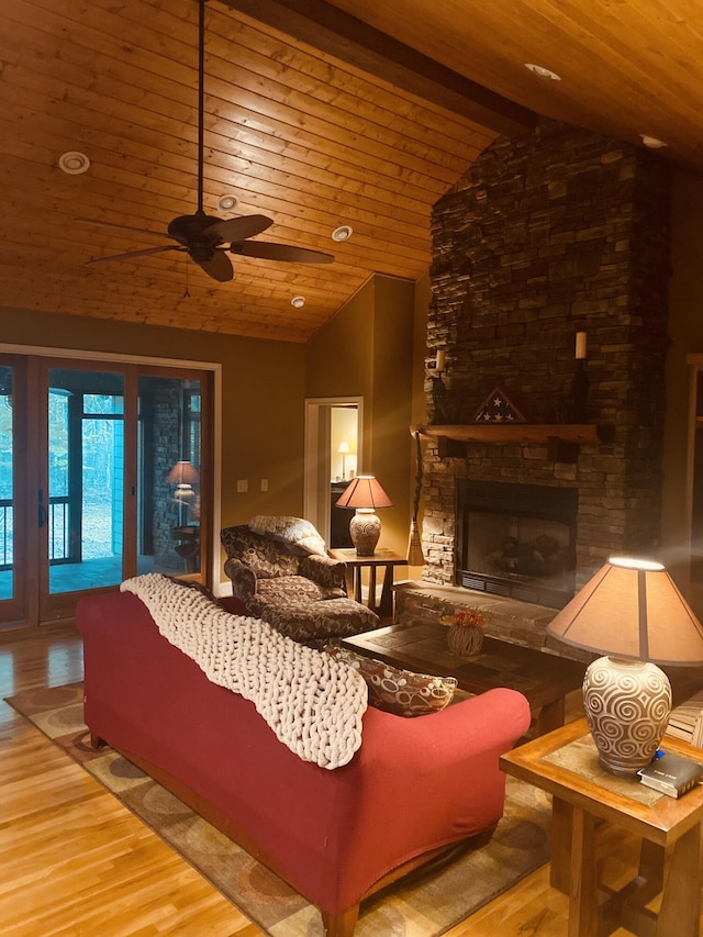 living room with wooden ceiling, lofted ceiling with beams, a stone fireplace, hardwood / wood-style flooring, and ceiling fan