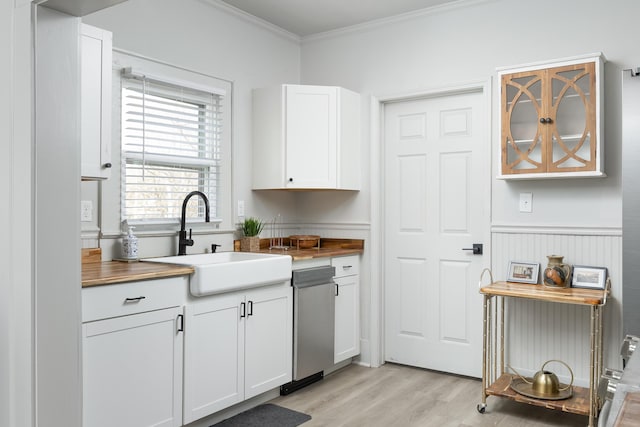 kitchen with crown molding, sink, stainless steel dishwasher, light hardwood / wood-style floors, and white cabinetry