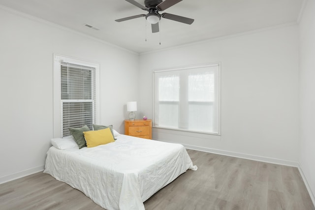 bedroom featuring ceiling fan, ornamental molding, and light wood-type flooring