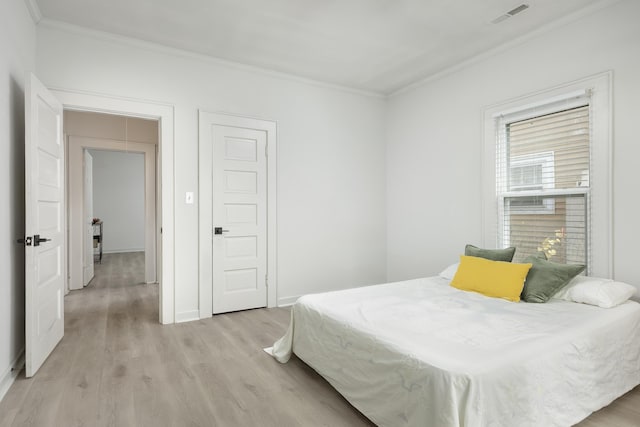 bedroom featuring light hardwood / wood-style floors and ornamental molding