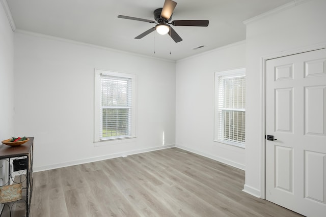 spare room with ceiling fan, light wood-type flooring, and crown molding